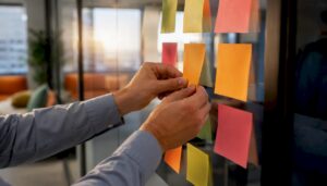 Hands placing sticky notes on glass for revenue growth planning